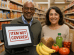 "African American man and Hispanic woman standing at a grocery store checkout with OTC card declined &mdash; register shows 'Item Not Covered' as they attempt to purchase healthy food."